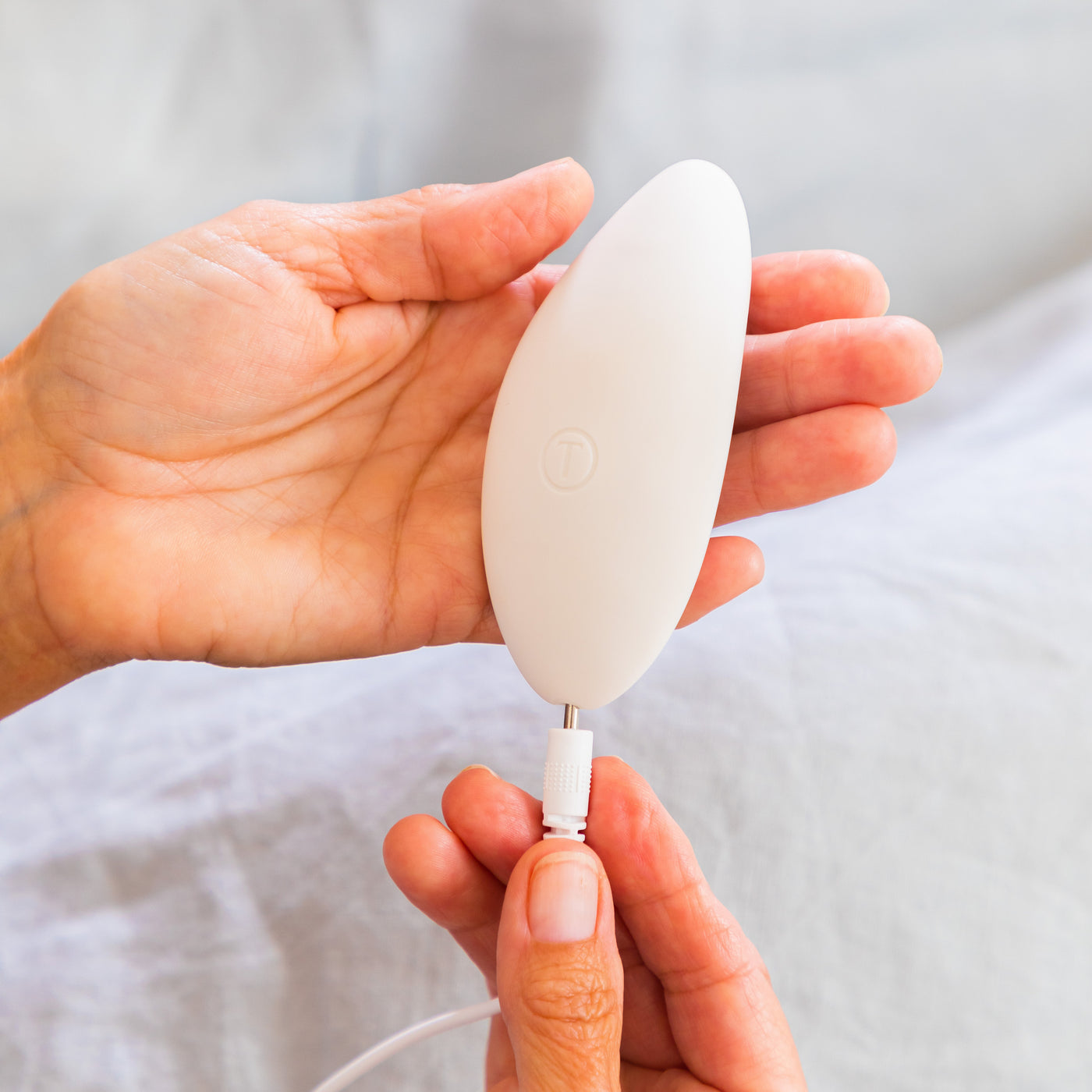 A woman charging the Pearl massager